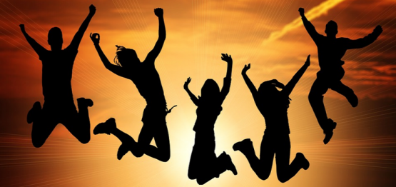 silhouette of five youth jumping with joy on the background of a sunset